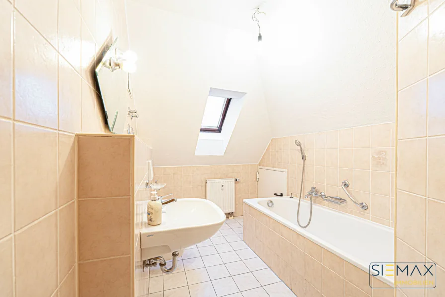 Badezimmer mit Badewanne und Zugang zum Kniestock