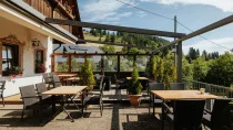 Sonnige Terrasse des Restaurants mit Windschutz