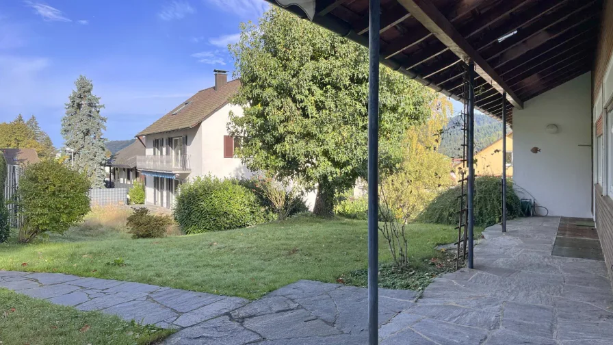 Überdachte Terrasse mit westlicher Ausrichtung und Blick in den Garten