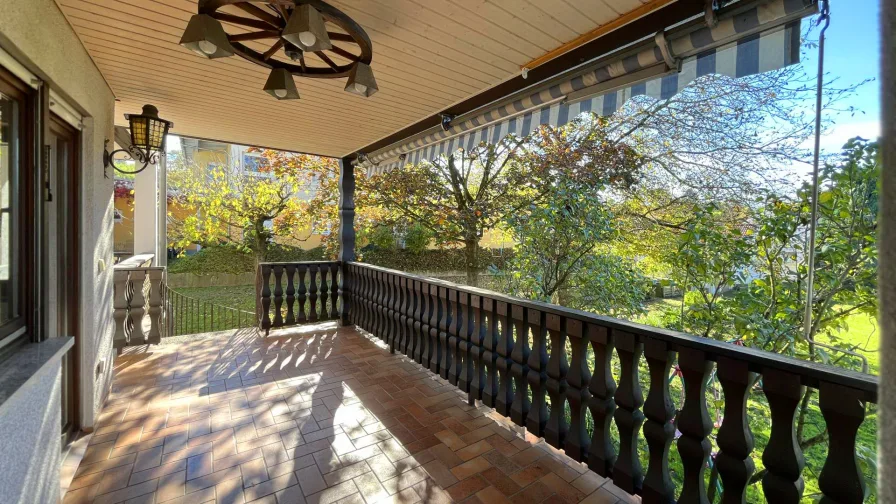 Überdachter Balkon mit Blick in den großen Garten