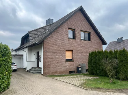 Titelbild - Haus kaufen in Hüllhorst - Gepflegtes Zweifamilienhaus mit Weitblick in einer ruhigen Anliegerstraße von Hüllhorst!