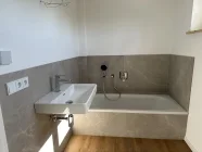 Badezimmer im 1. Obergeschoss mit Wanne und Dusche sowie Waschtisch/ WC