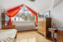 großes Schlafzimmer mit Giebelfenster und Hochbett