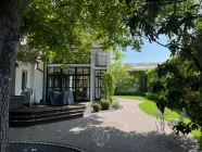 Blick vom Nebenhaus auf das Haupthaus und den Hof-/Gartenbereich