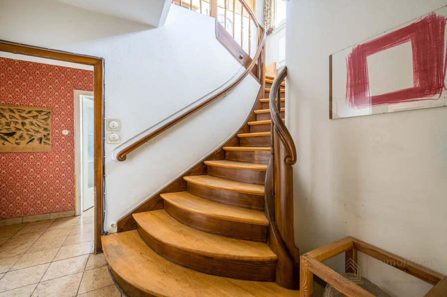 schön geschwungene Holztreppe ins Obergeschoss