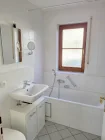 Blick ins helle OG-Bad mit Wanne, Waschbecken und WC
