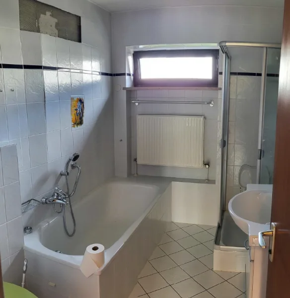 Blick ns Badezimmer mit Wanne, Dusche, WC