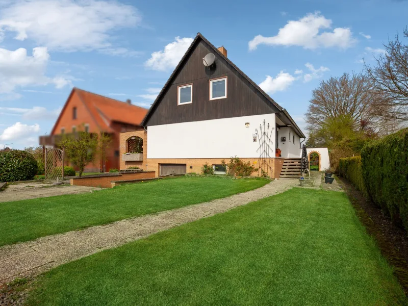 Titelbild - Haus kaufen in Niedernwöhren - Charmantes  Einfamilienhaus mit Einliegerwohnung in Niedernwöhren