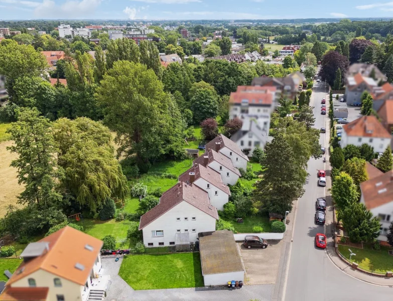 Blick auf die Häuser - Haus kaufen in Hannover - Vier vermietete Reihenhäuser im Block mit vier Garagen auf großem Grundstück in Hannover-Wettbergen