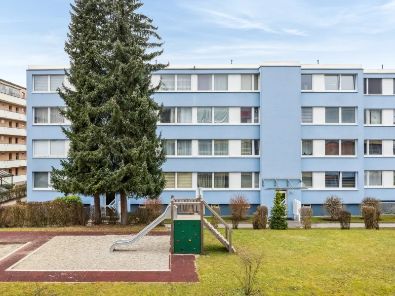 Hausansicht und Spielplatz - Wohnung kaufen in Neufahrn bei Freising - Gut geschnittene 3-Zimmer-Wohnung mit großen Gestaltungsmöglichkeiten in praktischer Lage (Neufahrn)