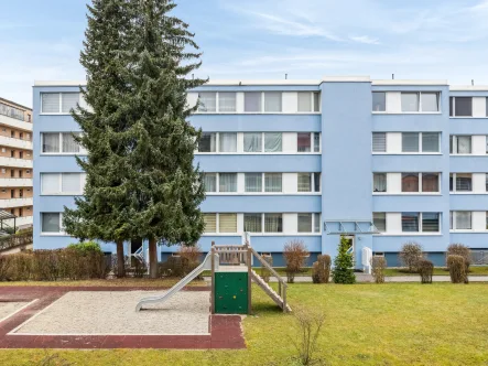 Hausansicht und Spielplatz - Wohnung kaufen in Neufahrn bei Freising - Gut geschnittene 3-Zimmer-Wohnung mit großen Gestaltungsmöglichkeiten in praktischer Lage (Neufahrn)