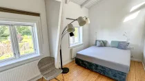 Schlafzimmer der Loftwohnung mit Blick über den Garten.