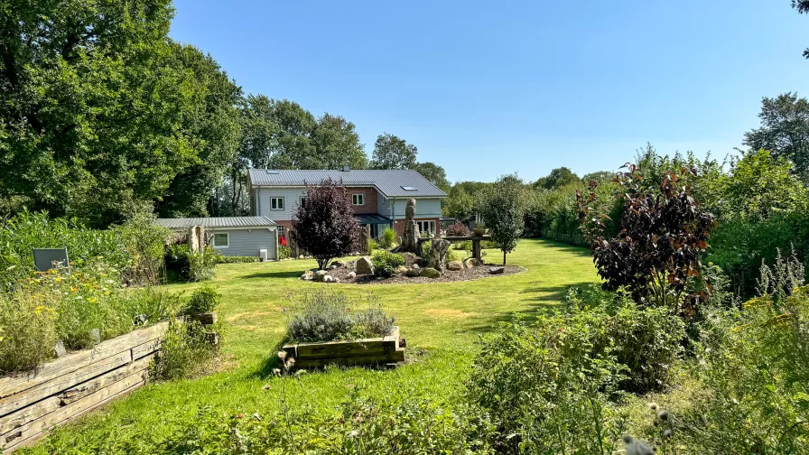 Aussicht! Ein Blick über Bienenwiese, Beet und Garten hinüber zum Haus.