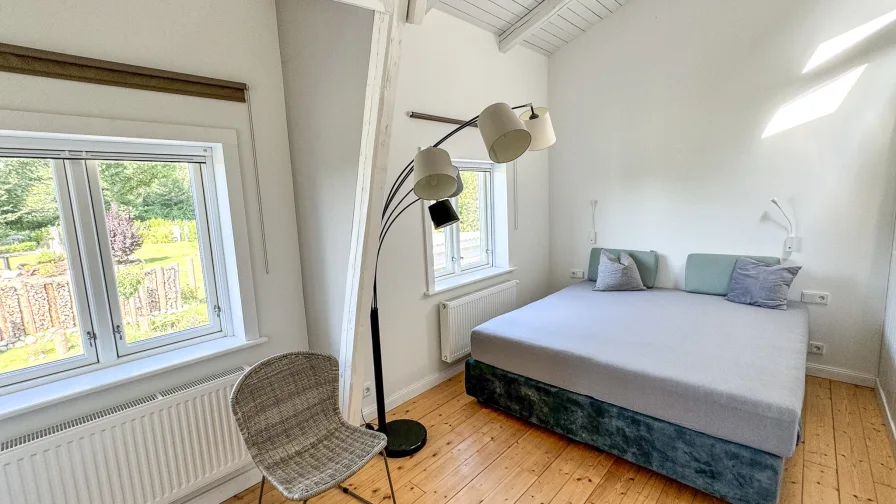 Schlafzimmer der Loftwohnung mit Blick über den Garten.