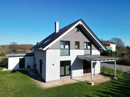 Hausansicht mit Terrasse - Haus kaufen in Wesertal - Ein Traum im Weserland – Exklusives Neubau-Refugium in Gieselwerder