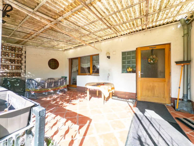 überdachte Terrasse mit Blick in den Garten