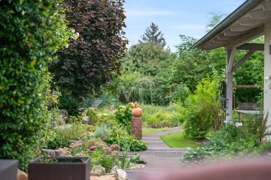 Weg vom Haus in den Garten mit Blick auf die Sommerküche