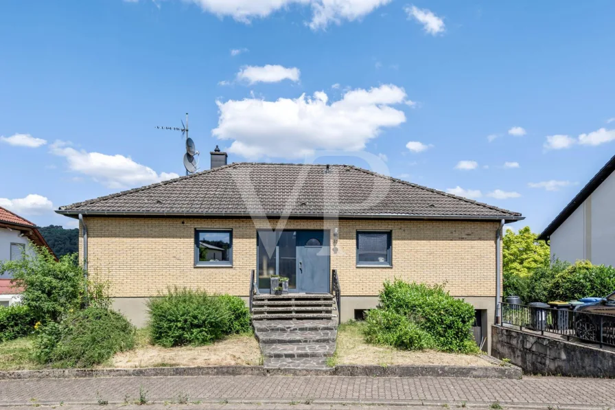 Straßenansicht - Haus kaufen in Rehlingen-Siersburg - Idyllischer Winkelbungalow: Naturnahes Wohnen in harmonischer Umgebung