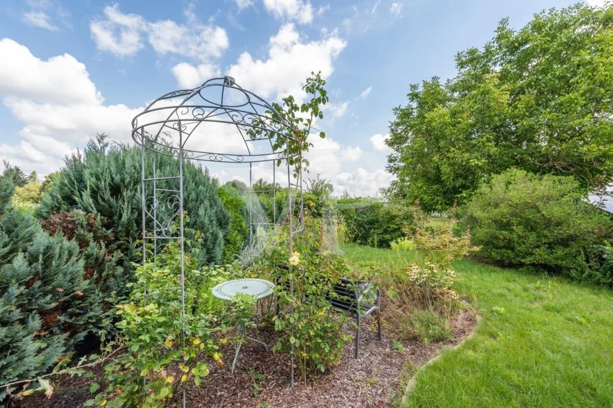 Liebevoll angelegter Garten mit kleinem Teich, Pavillon und Sitzbank