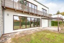 Hausansicht von vorne mit Blick auf die Terrasse und den Wintergarten