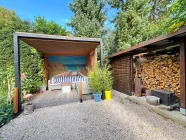 Loggia im Garten mit Feuerholz