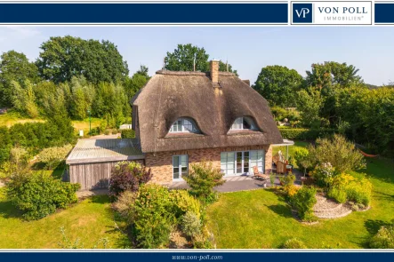 Titelbild - Haus kaufen in Achterwehr - Charmantes Reetdachhaus im Sylter Stil in traumhafter Feldrandlage in Achterwehr