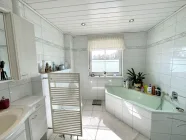 Badezimmer mit großer Eckbadewanne und Dusche im Erdgeschoss
