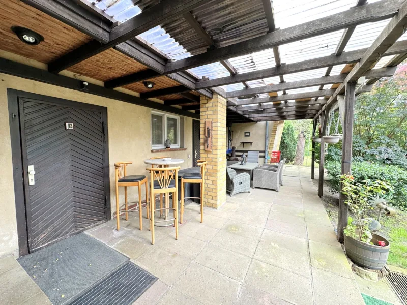 überdachte Terrasse mit Blick in den Garten