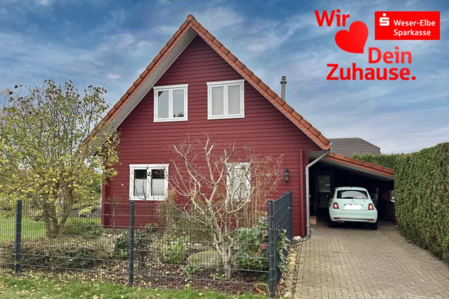 Giebelansicht + Carport - Haus kaufen in Geestland - Holzbohlenhaus in ruhiger Lage