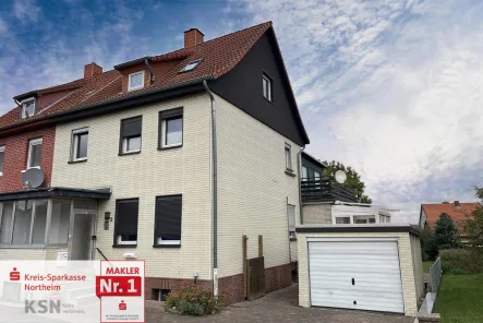 Vorder- und Seitenansicht mit Garage - Haus kaufen in Northeim - Doppelhaushälfte mit schönem Grundstück in Hillerse bei Northeim!