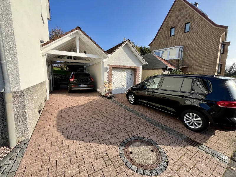 Einfahrt mit Carport und Garage