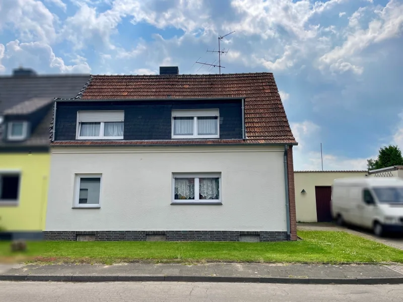 Ansicht von der Straße - Haus kaufen in Rheinberg - Aktuell vermietete Doppelhaushälfte mit großem Garten und Garage!