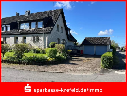 Front - Haus kaufen in Krefeld - Doppelhaushälfte mit zwei Garagen und Baugrundstück 