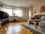 Großes Wohnzimmer mit Parkettfußboden und Balkon