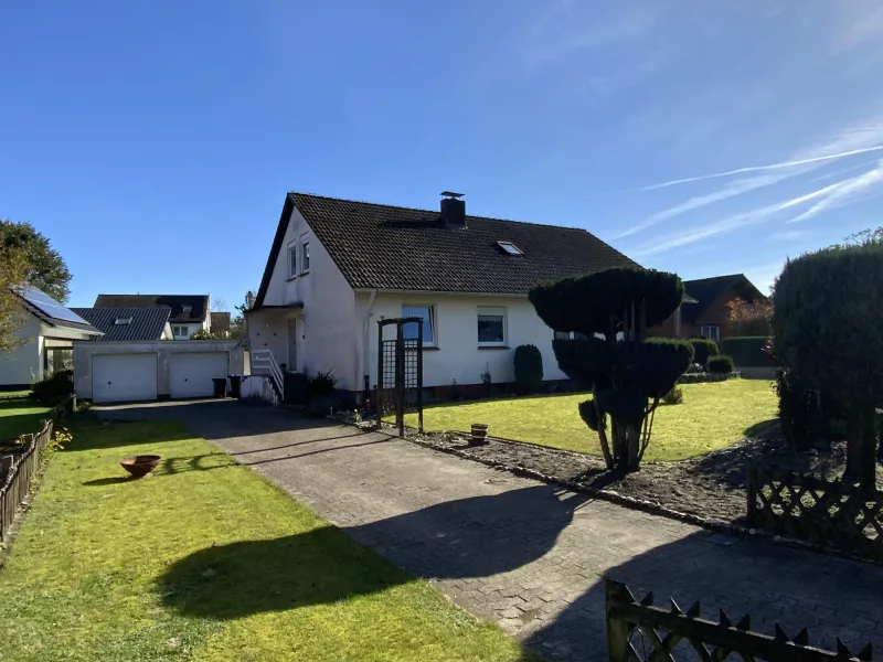 Straßenansicht mit Zufahrt und Garagen - Haus kaufen in Oerlinghausen - Wohnen auf einer Ebene mit Ausbaureserven!