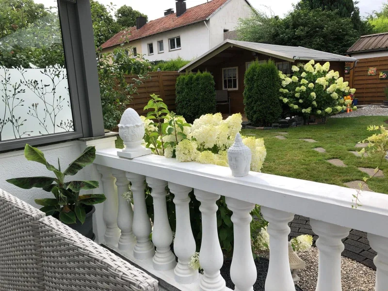 Blick von der überdachten Terrase aus in den Garten