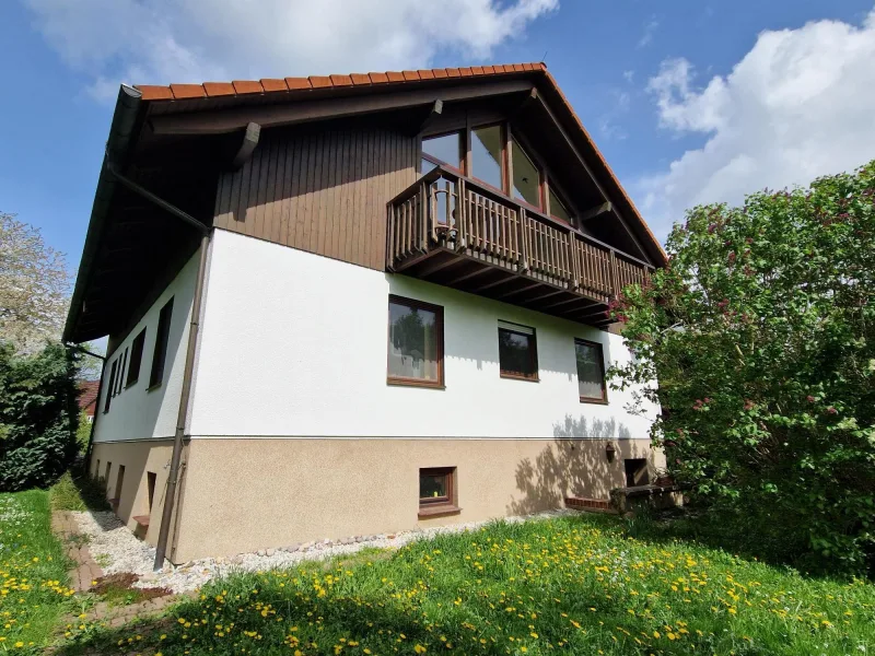 Giebelseite mit großer Fensterfront und Balkon