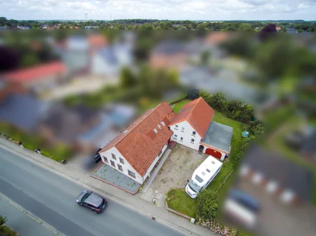 Straßenansicht - Haus kaufen in Leck - Vielseitiges Dreifamilienhaus: Mehrgenerationenhaus oder solide Kapitalanlage mit Potenzial!