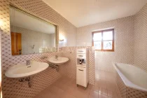 Badezimmer mit Doppelwaschbecken, Wanne und WC