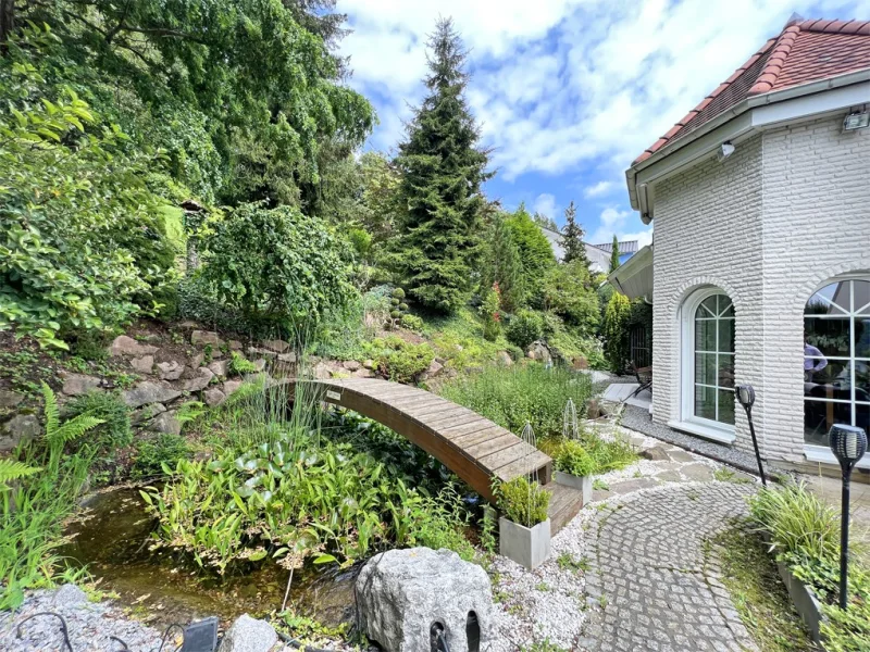 Der eigene Teich mit kleinem Wasserfall rundet den Terrassenbereich zauberhaft a