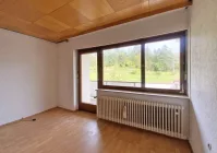 Zimmer mit Zugang zum Balkon im Erdgeschoss