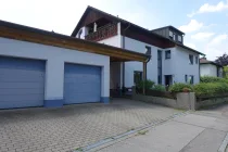 Hausansicht mit Garagen und Carport