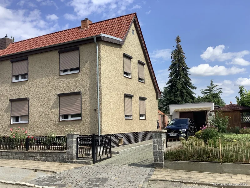 Straßenansicht mit Einfahrt - Haus kaufen in Oschersleben - DHH in ruhiger Wohnsiedlung