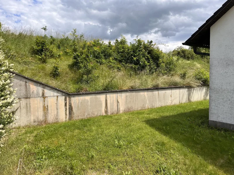 ebene Gartenfläche mit Einfriedungsmauer nach Osten