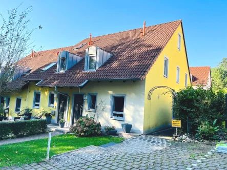 Ansicht des Hauses - Haus kaufen in Haßfurt - Wohnen im stadtnahen Grün! 4 Zimmer-Reihenhauswohnung mit Keller, Terrasse, Garten, Stellplatz + TG-Stellplatz, Wohnfl. 110m²