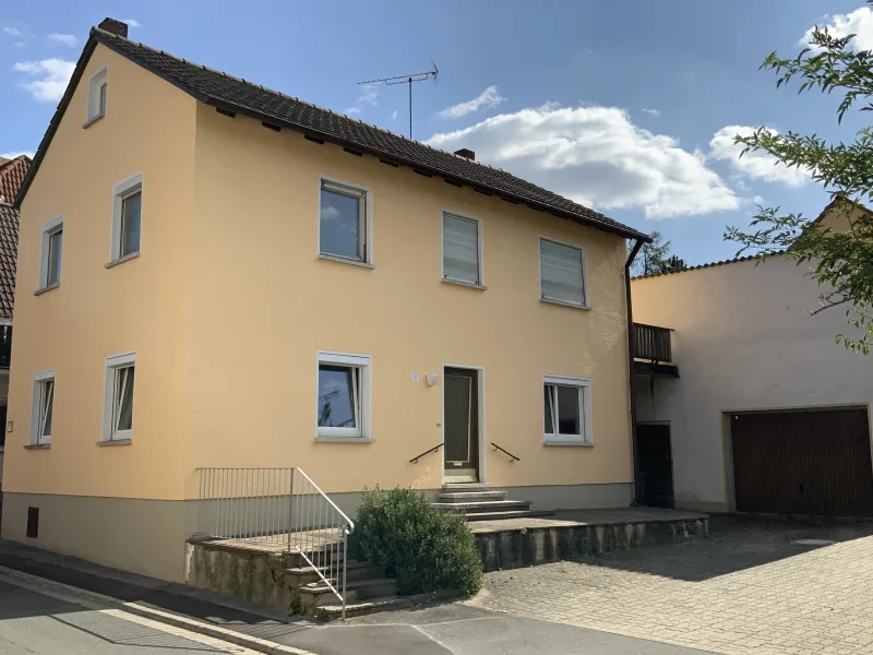 Straßenansicht - Haus kaufen in Walsdorf - Sanierungsbedürftiges Einfamilienhaus mit Garage und Nebengebäude im Ortskern von Walsdorf