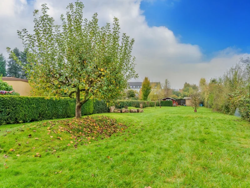 Idyllischer Garten mit Obstbaumwiese und rustikaler Blockhütte