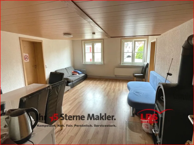Wohnzimmer mit Ofen - Wohnung kaufen in Meßkirch - 7 % Rendite! Modernisierte 6-Zimmer-Wohnung mit EBK