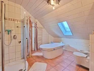 Geräumiges Badezimmer mit luxuriösen Details und Balkonzugang