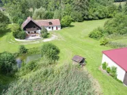 Ansicht aus Südosten mit Haus, Garage und Wasserfläche